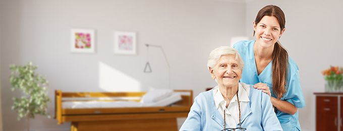 a nurse smiling at the camera with an elderly lady
